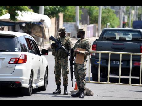 In this July 2020 photo, JDF soldiers conduct a spot check at a checkpoint in Greenwich Town during a state of emergency. 