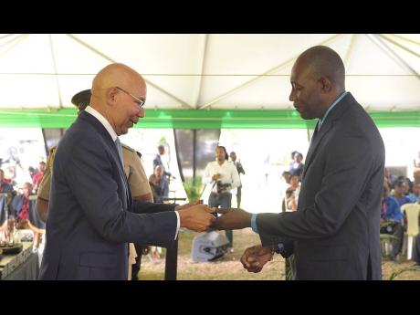  Governor-General Sir Patrick Allen (left), presents an award to O’Neil Hamilton for over 25 years of service to the Office of His Excellency the Governor-General and Staff, during the Jamaica Civil Service Long Service Awards Ceremony on November 23.