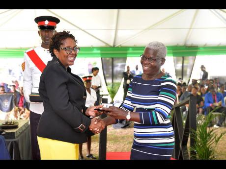 Member of Parliament for St Andrew South Western, Dr Angela Brown Burke (left), makes a presentation to Andrea Bell-Shaw for over 25 years of service to the Northeast Regional Health Authority during the Jamaica Civil Service Long Service Awards Ceremony, 