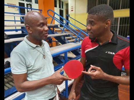 Thanks Dad: Mark Phillips (right) tells his father Donald how his racquet helped him to win the JTTA President’s Trophy Men’s Open at G.C. Foster College on Saturday.