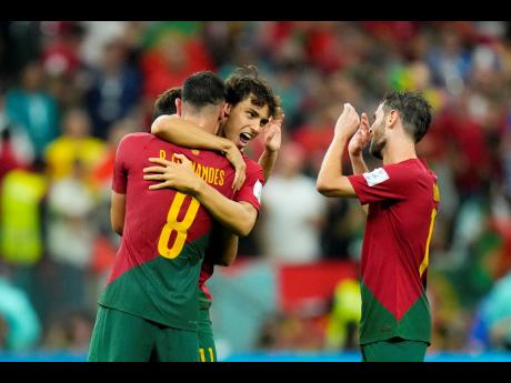 From left: Portugal's Bruno Fernandes, Joao Felix and Bernardo Silva, celebrate at the end of their World Cup group H football match against Uruguay, at the Lusail Stadium in Lusail, Qatar, this afternoon.