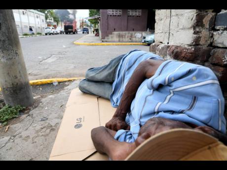 Credit: File A homeless man uses a flattened cardboard box as a bed to sleep on a sidewalk in downtown Kingston.