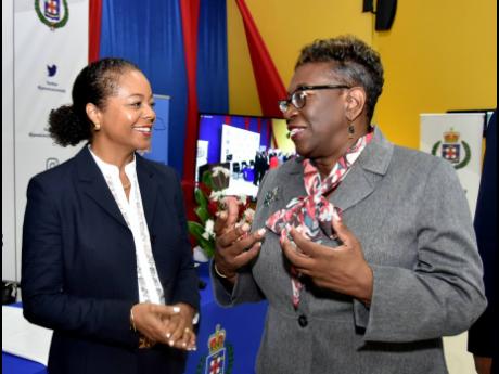 Minister of Legal and Constitutional Affairs Marlene Malahoo Forte (left) listens to Director of Public Prosecutions Paula Llewellyn during a hybrid Criminal Investigation Branch conference geared at understanding the new Firearms Act. The conference took 