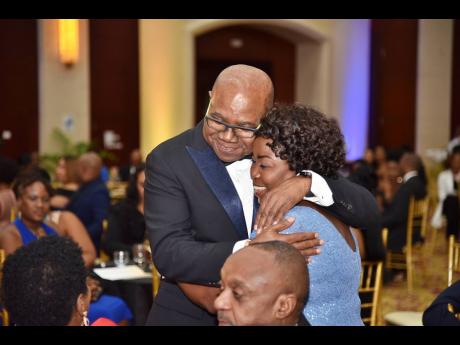 Gloria Henry gets a big hug from Minister of Tourism Edmund Bartlett after accepting the 2022 Business Leader Wall of Fame award from the Montego Bay Chamber of Commerce and Industry at the Montego Bay Convention Centre last Saturday night.