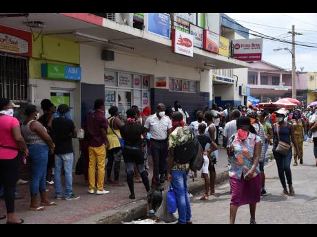 
In this April 2020 photo, a large crowd is seen gathered along the main street in Linstead, St Catherine, waiting to access remittances
