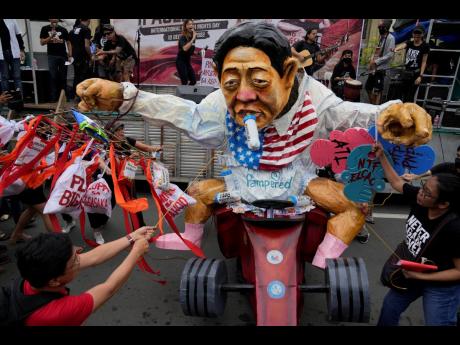 Protesters pull an effigy of Philippine President Ferdinand Marcos Jr. during a rally as they commemorate International Human Rights Day, in Manila. 