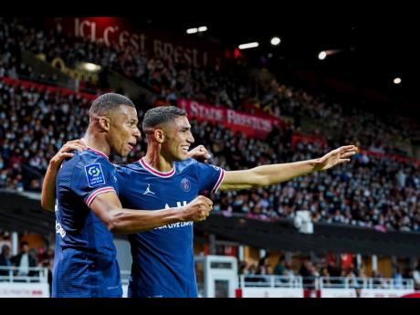 Credit: AP PSG’s Kylian Mbappe (left) celebrates with teammate Achraf Hakimi after scoring his side’s second goal during a French League One football match between Brest and PSG at the Francis-Le Ble stadium in Brest, France, on Friday, August 20, 2021.