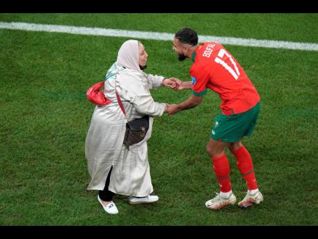 Morocco’s Sofiane Boufal (right) celebrates with his mother after his team’s win in the World Cup quarterfinal soccer match against Portugal at Al Thumama Stadium in Doha, Qatar, on Saturday.