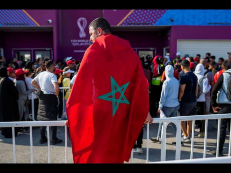 Credit: AP A man draped in a Moroccan flag queues with supporters outside the Al Janoub Stadium in Wakrah, Qatar, yesterday in the hope of getting tickets for today’s World Cup semifinal football match between France and Morocco.
