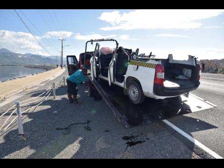 The wrecked Toyota Probox vehicle being placed on a wrecker after it collided with a Toyota Prado along the Palisadoes Road in St Andrew on Sunday. Four people, who were travelling in the motorcar, died.