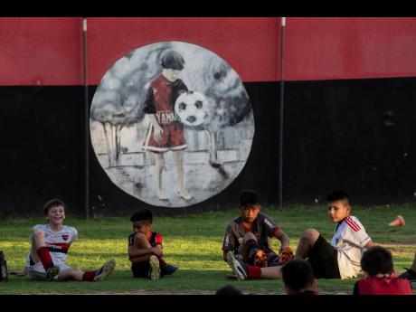 Children relax during a training on Wednesday in a football school at Newell's All Boys club, where Lionel Messi played as a kid in Rosario, Argentina.
