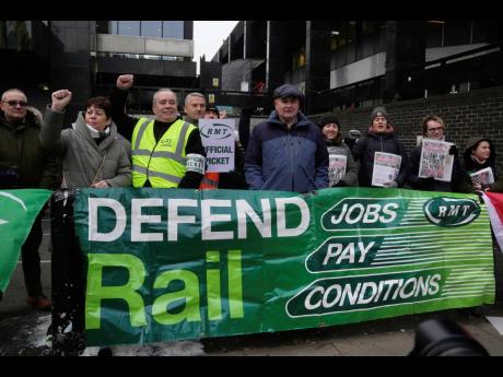 Mick Lynch, general secretary of the Rail, Maritime and Transport union (RMT), centre, joins the members of rail workers during a strike outside Euston station in London.