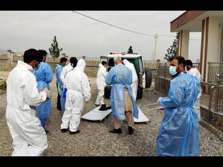 Doctors collect the bodies of victims of a fuel tanker explosion in the Salang Tunnel through the Hindu Kush mountains, north of Kabul, Afghanistan.