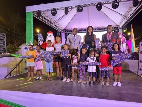 Credit: Christopher Thomas From right, back row: Montego Bay’s Mayor Leeroy Williams; Verona Carter, vice president of public affairs for New Fortress Energy; and Bishop Conrad Pitkin, custos of St James, in a group shot with Santa Claus and several children who received Christmas