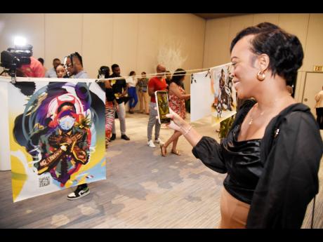 Credit: Nicholas Nunes/Photographer Roshea Masters scans the bar code of Bonito ‘Don Dada’ Thompson’s artwork dubbed ‘The Diplomat’.