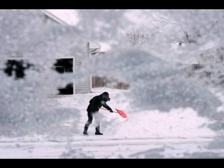 Credit: AP A local resident shovels snow off the end of a driveway yesterday in Urbandale, Iowa. Temperatures plunged far and fast yesterday as a winter storm formed ahead of Christmas weekend, promising heavy snow, ice, flooding and powerful winds across a broad swa
