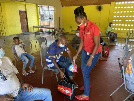 Marjaalaine Francis hands out a Christmas care package to a senior citizen in Payne Avenue. The foundation distributes over 900 care packages across six communities annually.