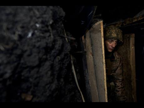 Credit: AP A Ukrainian soldier walks at a frontline position near Maryinka, Donetsk region, Ukraine yesterday.