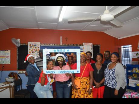  The SAJ team shares a light moment with teachers at the Marcus Garvey Basic School during its annual treat for the students.
