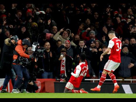 Arsenal’s Eddie Nketiah (centre) celebrates after scoring his side’s third goal during the English Premier League match between Arsenal and West Ham United at Emirates stadium in London yesterday. 