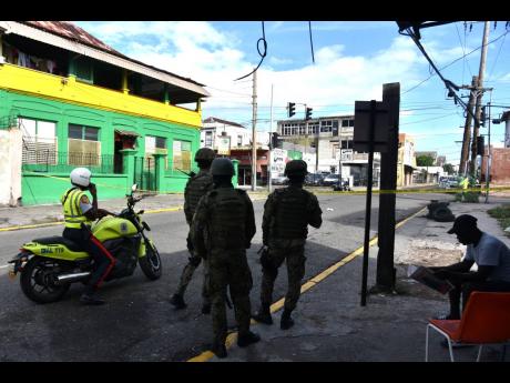 JDF soldiers and a policeman near scene of crime, where a policeman was shot and injured on East Queen Street in Kingston in November.  File