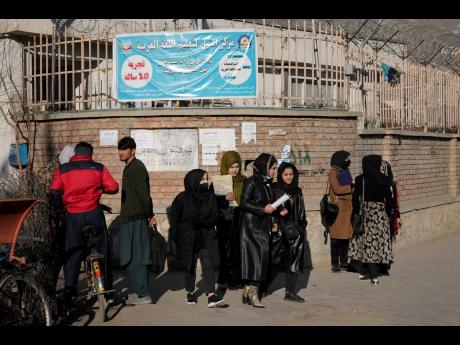 Afghan women students stand outside the Kabul University in Kabul, Afghanistan, on December 21.