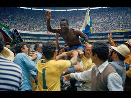 In this June 21, 1970 file photo, Brazil’s Pelé is hoisted on the shoulders of his teammates after Brazil won the World Cup soccer final against Italy, 4-1, in Mexico City’s Estadio Azteca, Mexico.