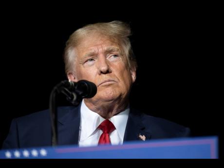 FILE - Former President Donald Trump pauses while speaking at a rally at the Minden Tahoe Airport in Minden, Nevada, on October 8.