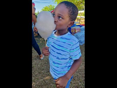 This little boy enjoys a nice cotton candy at a community Christmas Treat hosted for residents of the Bluefields community by the Bluefields Villas Foundation recently.