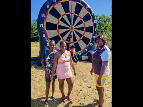 These ladies paused for a quick photo as two youngsters play with an inflated dart wheel 