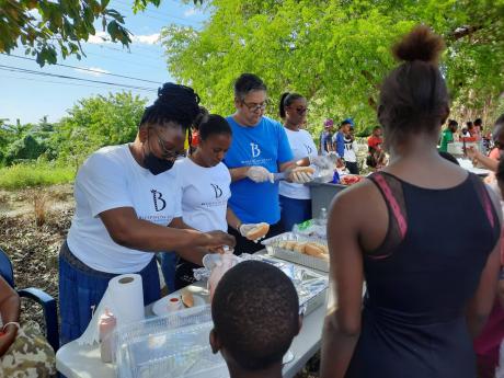 (From left) Carmen Hibbert, food and beverage manager; Arianna Yates, guest services assistant;  Houston Moncure, managing director and Mikalia Eubanks, guest services assistant, serve some hotdogs at Bluefields Villas Foundation Christmas treat.
