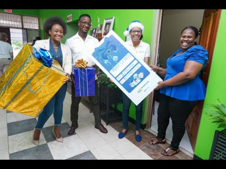 Mary’s Child administrator Nadia Williams (right), is greeted by NCB Foundation Director Tracy-Ann Spence (second right) and her Grant a Wish elves Jodi-Ann Fearon and Nickcarter Wittock. Mary’s Child, a home for teenaged mothers, received the $250,000