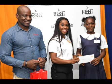 Credit: File From left: Elon Parkinson, head of public relations at Digicel, supports Shelly-Ann Fraser-Pryce, as she makes a presentation to Ranicka Bryan. Fraser-Pryce is a Digicel brand ambassador.