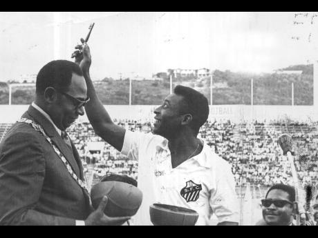 
Brazil’s football maestro Edson Arantes do Nascimento (Pelé) holding up the Key to the City, which he received from Mayor of Kingston Councillor Emerson Barrett before the start of the match in 1971 between Santos of Brazil and Cavalier Invitational te