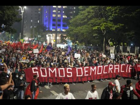Credit: AP Demonstrators march holding a banner that reads in Portuguese ‘We are Democracy’ during a protest calling for protection of the nation’s democracy in Sao Paulo, Brazil, on Monday, a day after supporters of former President Jair Bolsonaro stormed gove
