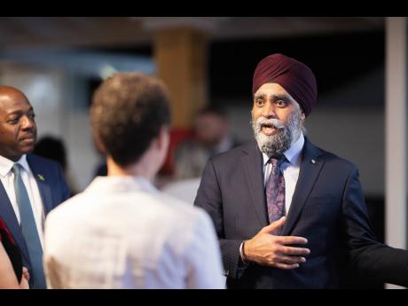 Minister of International Development from Canada Harjit S. Sajjan (right), has the attention of Minister of Agriculture and Fisheries Pearnel P. Charles Jr (left) and Minister of Foreign Affairs and Foreign Trade  Senator Kamina Johnson Smith.