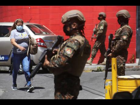 Credit: AP In this March 2022 photo, soldiers man a checkpoint at the entrance to the Las Palmas community, a neighbourhood that is supposedly under the control of Barrio 18 Gang in San Salvador.