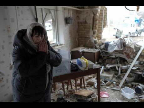Halina Panasian, 69, reacts inside her destroyed house after a Russian rocket attack in Hlevakha, Kyiv region, Ukraine, Thursday, January 26.
