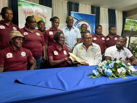 Credit: Tamara Bailey Chief executive officer of Home Grown Produce (HGP), Damion Young (front centre), with members of the Top Burnt Ground farm group, shortly after signing contracts at the recent agribusiness symposium to increase legume production in the parish. Looking on