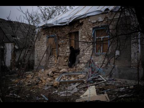 Oleksandra Hryhoryna inspects her house which was damaged by shelling last fall in Kalynivske, Ukraine.
