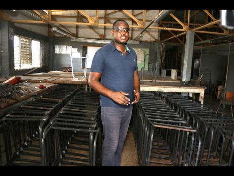 Burchell Simmonds, head of Vere Technical High’s Engineering Department, displays the metal frames for desks that are part of the Ministry of Education and Youth’s school furniture programme.