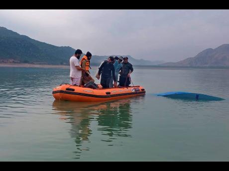 Credit: Uncredited Rescue workers search for bodies after a boat with students capsized in northwest Pakistan on Sunday.