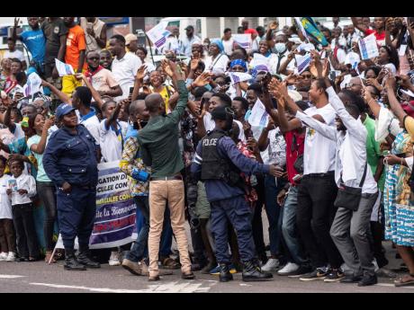 Well-wishers wave at Pope Francis in Kinshasa, Congo, yesterday. Francis is in Congo and South Sudan for a six-day trip, hoping to bring comfort and encouragement to two countries that have been riven by poverty, conflicts ,and what he calls a ‘coloniali