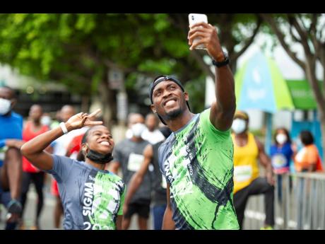 Olympic medallist Megan Tapper (left) and Hansle Parchment at last year’s 24th staging of the Sagicor Sigma Corporate Run.