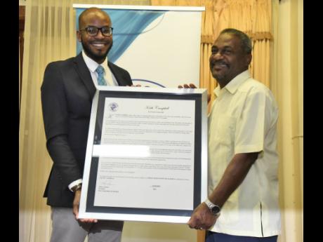 Credit: Ian Allen/Photographer Jovan Johnson (left), treasurer of the Press Association of Jamaica, presents a citation to Keith Campbell, veteran cameraman, technical director and production manager.