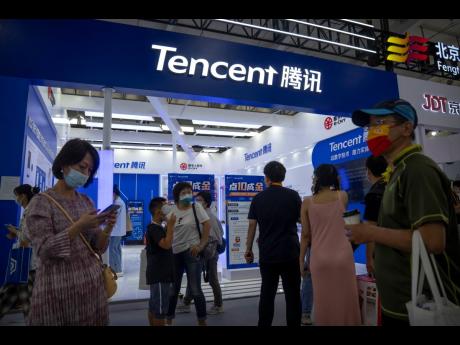 Visitors gather near a booth for Chinese technology firm Tencent at the China International Fair for Trade in Services in Beijing, on September 3, 2022. 
