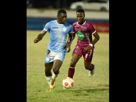Ricordo James (left) of Chapelton Maroons FC dribbles away from Earon Elliott of Faulkland FC during their Jamaica Premier League match at the  Ashenheim Stadium, Jamaica College on February 6, 2023. Faulkland won 1-0.