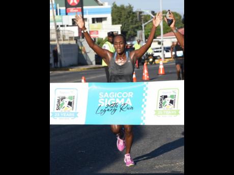 Credit: Ian Allen Jozanne Harris the first female to cross the finish line in the Sagicor Sigma 25th Legacy Run in New Kingston yesterday.
