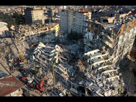 Rescue teams search for people as cranes remove debris from destroyed buildings in Antakya, southeastern Turkey, on Friday, February 10.