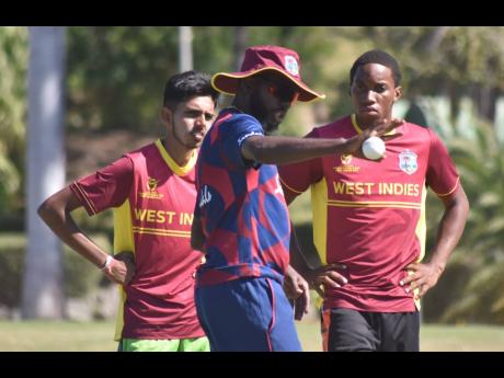 Former Jamaica and West Indies spinner Nikita Miller (centre) explains some training drills to Guyana’s Golcharan Chulai (left) and Tarrique Edwards from the Windward Islands during the CWI Rising Stars High-Performance Camp in Antigua on Friday. 